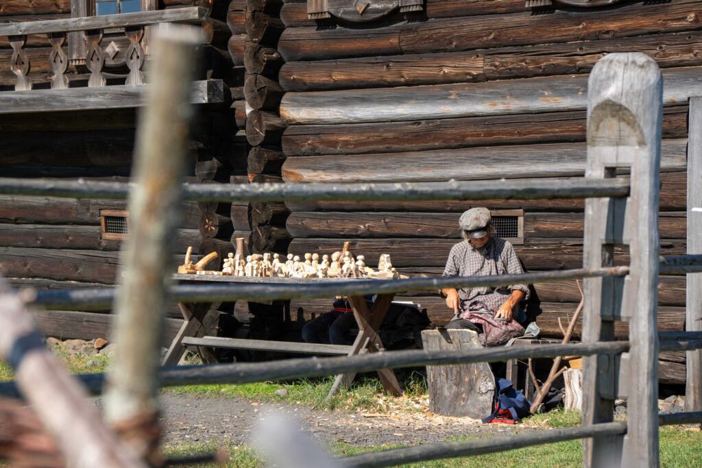 Ремесленник вырезает фигурки из дерева на острове Кижи