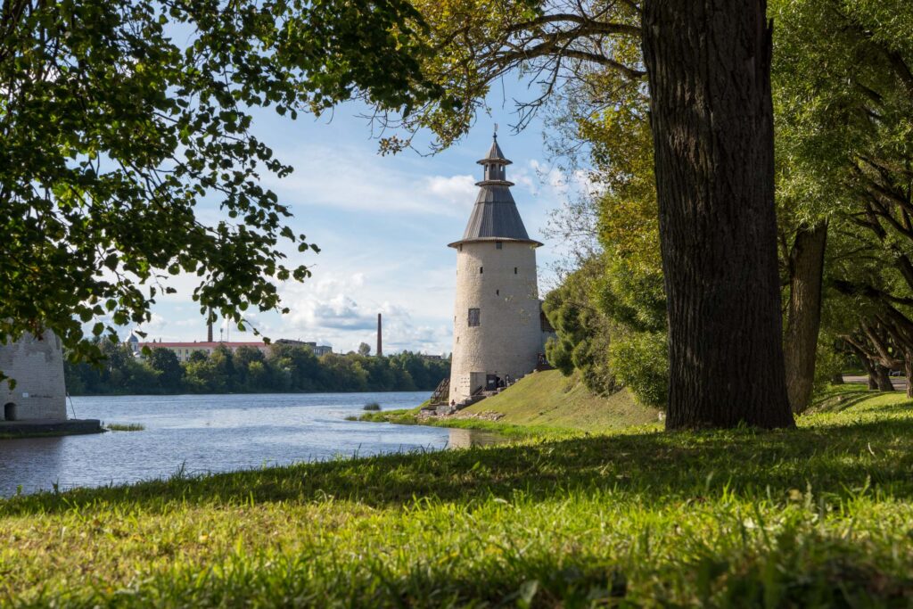 Башня в Пскове среди деревьев