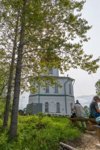 Отдых у храма на Секирной горе где паломники сидят на скамейках у тропы
