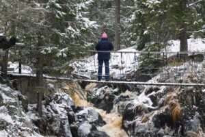 Турист на мосту над потоком Ахвенкоски