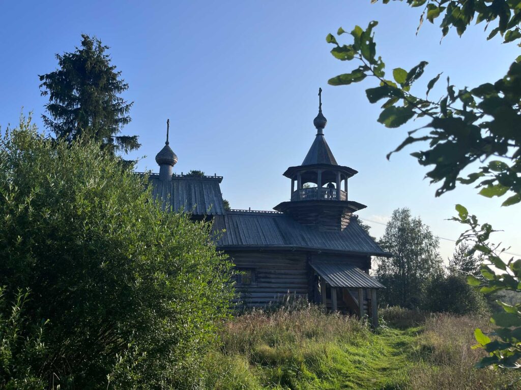 Часовня Маньги среди летней листвы