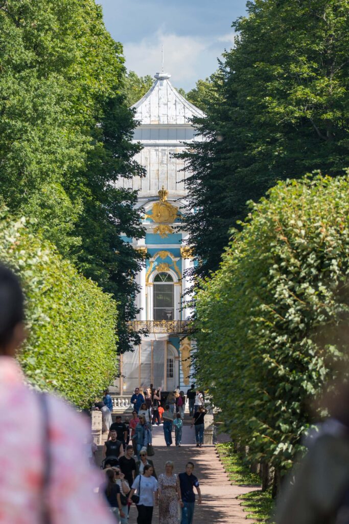 Барочный павильон Эрмитаж в конце зелёной аллеи с посетителями