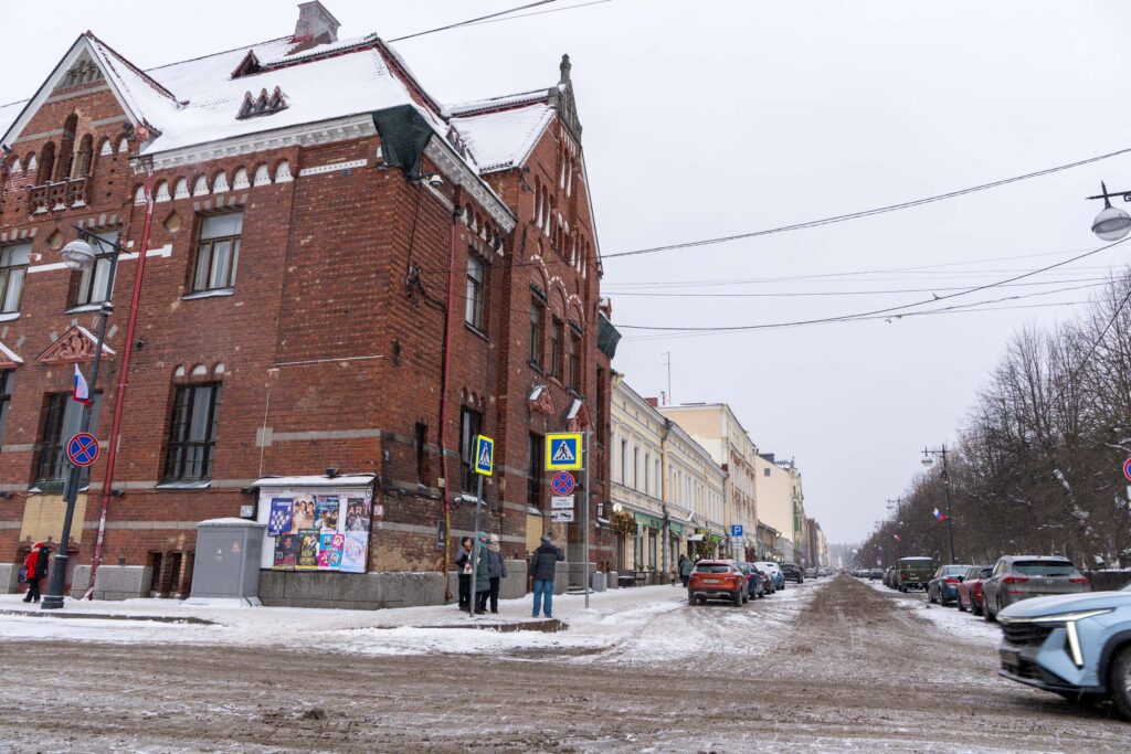 Угол Банка Финляндии у проспекта Ленина с пешеходами зимой