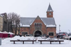 Выборгский рынок с часовой башней за двумя заснеженными скамейками